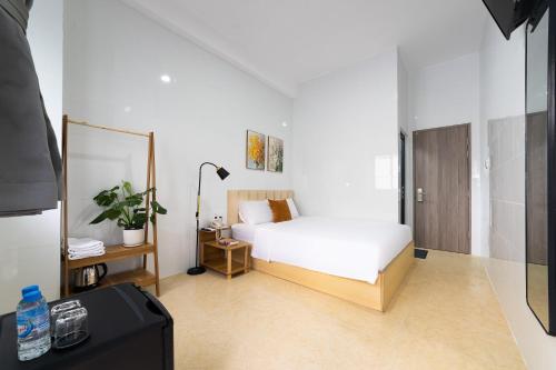 a bedroom with a white bed and a mirror at Thiên Quốc Hotel in Ho Chi Minh City