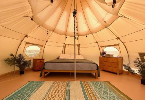 a bedroom with a bed in a large tent at North Shore Glamping Camping Laie, Oahu, Hawaii in Laie