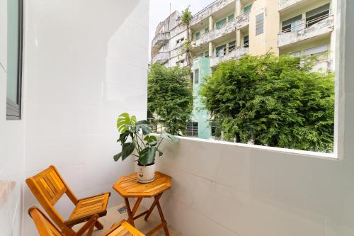 a balcony with two chairs and a potted plant at Thiên Quốc Hotel in Ho Chi Minh City