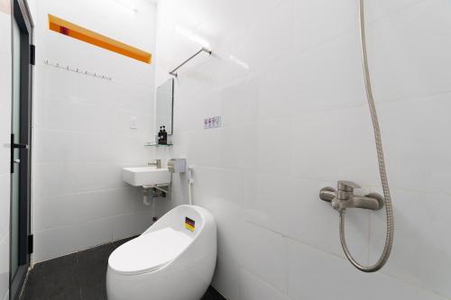 a white bathroom with a toilet and a sink at Thiên Quốc Hotel in Ho Chi Minh City