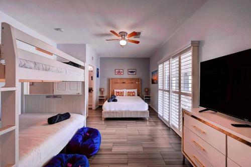 a bedroom with two bunk beds and a flat screen tv at Villa Del Sol in Henderson