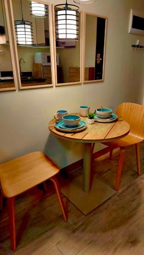 a wooden table with bowls and plates on it at Matawhay Staycation at One Regis in Bacolod