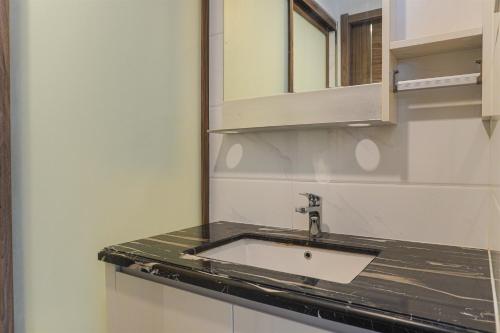 kuchnia ze zlewem i lustrem w obiekcie Serene and Modern 2BR Sky House BSD Apartment near AEON By Travelio w mieście Tangerang