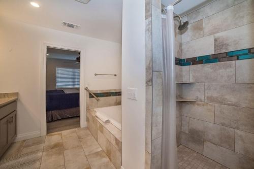 a bathroom with a walk in shower and a tub at Anchorage Haus in Fredericksburg