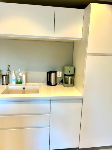 a kitchen with white cabinets and a sink at Havn i Etne with fjordview in Etnesjøen