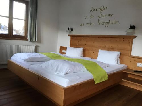 a bed with a wooden headboard in a room at Hinkerhof in Schladming