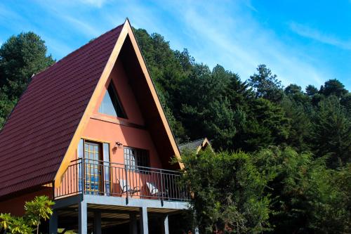 a house with a gambrel roof with a balcony at Recanto do Bosque in Campos do Jordão