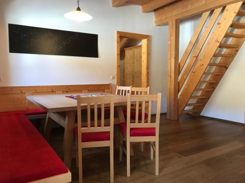 a dining room with a table and chairs and stairs at Hinkerhof in Schladming