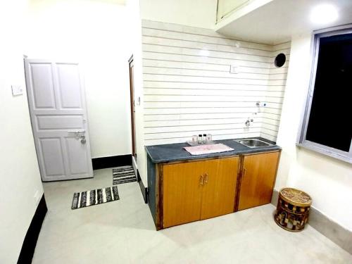 a bathroom with a sink and a window and a door at Studio Room Close to Quest Mall in Kolkata