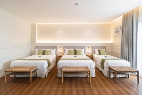 a hotel room with two beds and two benches at Bayandati Resort in Bataan