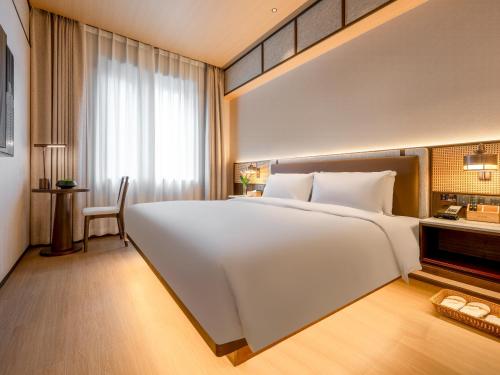 a large white bed in a hotel room at Beijing Renjoy Hotel in Beijing