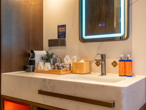 a bathroom counter with a sink and a mirror at Beijing Renjoy Hotel in Beijing