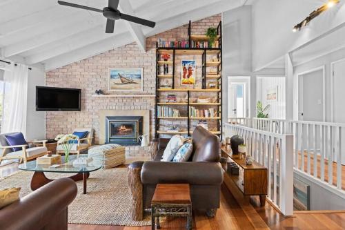 a living room with a couch and a fireplace at Bluewave Beach Getaway in Wamberal North