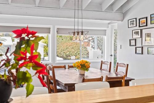 a dining room with a table and chairs and a window at Bluewave Beach Getaway in Wamberal North