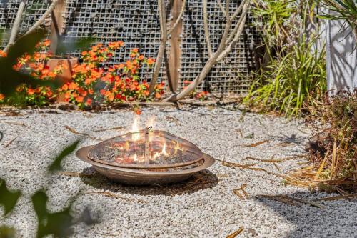 a fire pit sitting in the middle of a garden at Bluewave Beach Getaway in Wamberal North