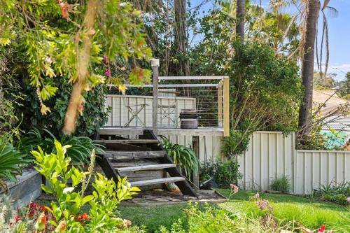 a set of stairs in a garden with a fence at Bluewave Beach Getaway in Wamberal North