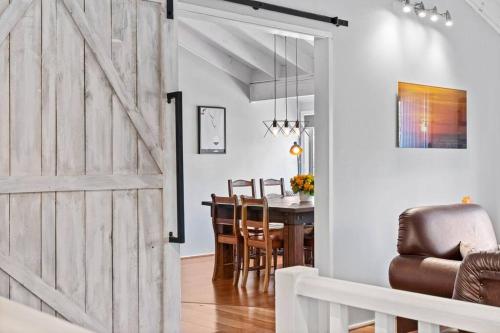 a sliding barn door in a dining room with a table at Bluewave Beach Getaway in Wamberal North