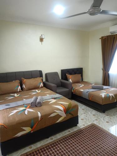 a room with two beds and a couch at Heal Inn - Islamic Guest Chalet in Kangar