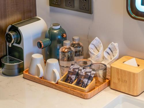a kitchen counter with a coffee maker and a tray of items at Beijing Renjoy Hotel in Beijing