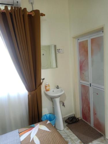 a bathroom with a sink and a shower at Heal Inn - Islamic Guest Chalet in Kangar