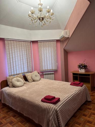a bedroom with a large bed with a chandelier at SunLake Hotel Osokorki in Kyiv