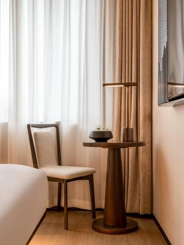 a bedroom with a bed and a chair and a table at Beijing Renjoy Hotel in Beijing