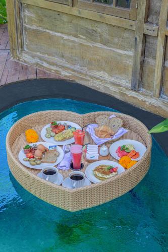 a tray of food on a table in the water at Abian Ubud View in Ubud
