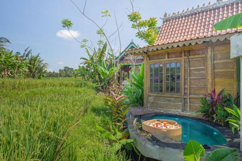 a hot tub in a garden next to a house at Abian Ubud View in Ubud