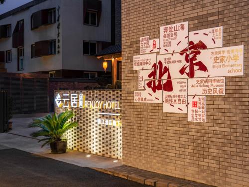 a brick wall with signs on the side of a building at Beijing Renjoy Hotel in Beijing
