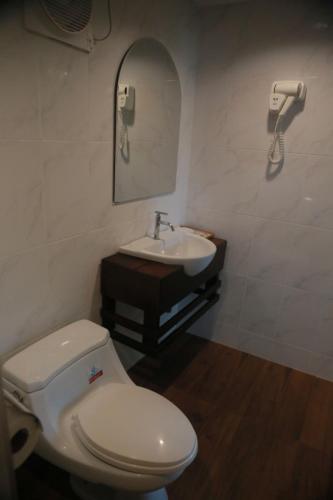 a bathroom with a white toilet and a sink at Rock and Tree House Resort in Khao Sok