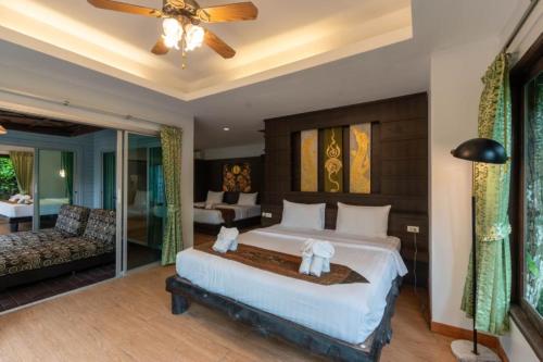 a bedroom with a large bed and a couch at Rock and Tree House Resort in Khao Sok