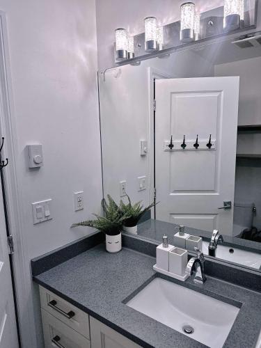 a bathroom with a sink and a mirror at The warm and lovely coach home in Vancouver