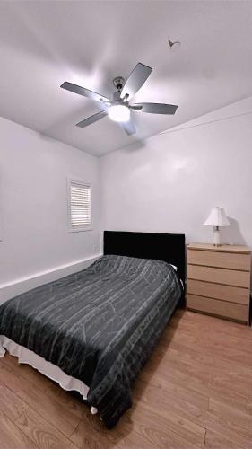 a bedroom with a ceiling fan and a bed at The warm and lovely coach home in Vancouver