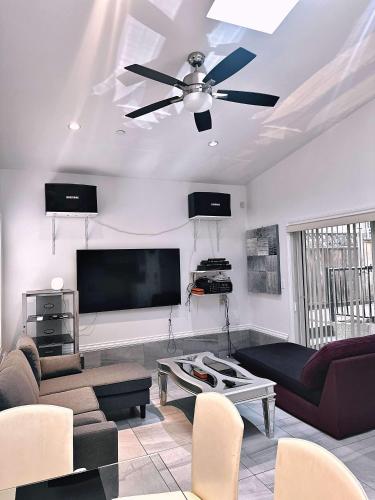 a living room with a ceiling fan and a flat screen tv at The warm and lovely coach home in Vancouver