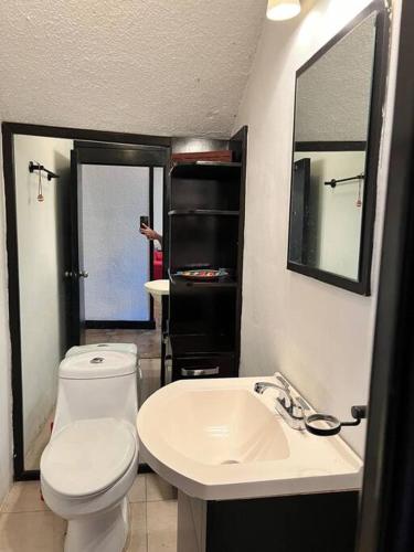 a bathroom with a white toilet and a sink at Casa con alberca 685 in Tuxtla Gutiérrez