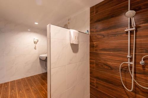 a shower stall in a bathroom with wooden walls at Rock and Tree House Resort in Khao Sok