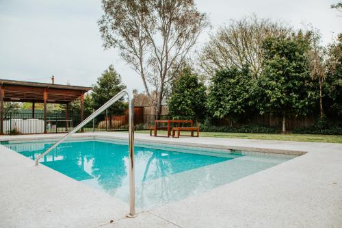 a swimming pool with a hand rail in a yard at Nagambie Waterfront Motel in Nagambie