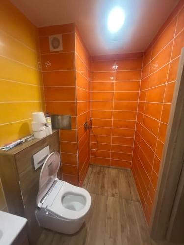 a bathroom with a toilet in an orange room at 3kk - centrum Havířova in Havířov