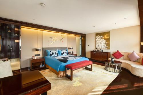 a bedroom with a blue bed and a couch at Crowne Plaza Chengdu Panda Garden by IHG-Near Panda Base in Chengdu