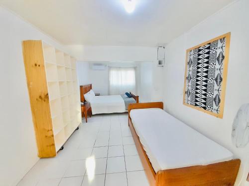 a small room with two beds and a window at Tonga Cottage - Entire Place with Aircon in Nuku‘alofa
