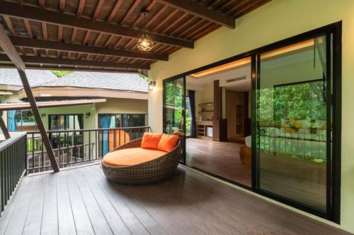 a porch with a chair on a balcony at Rock and Tree House Resort in Khao Sok