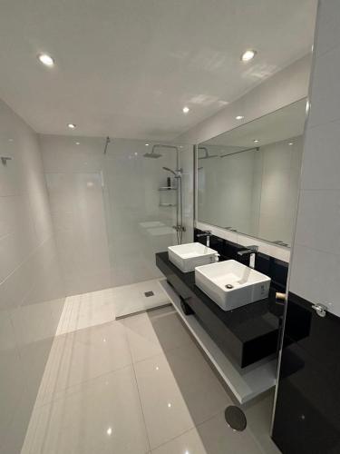 a white bathroom with a sink and a mirror at Primera línea Aquamarina Anfi del Mar in Los Caideros