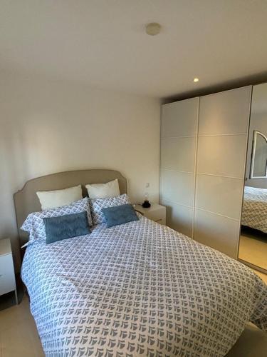 a bedroom with a large bed with blue pillows at Primera línea Aquamarina Anfi del Mar in Los Caideros