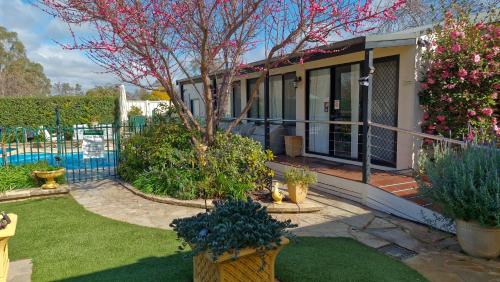 a house with a yard with plants and flowers at Courtsidecottage Bed and Breakfast in Euroa