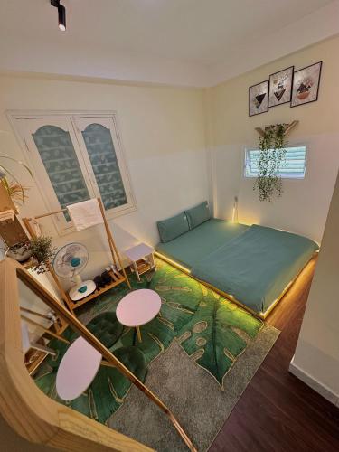 a bedroom with a green bed and a table and chairs at 1 House in Da Lat
