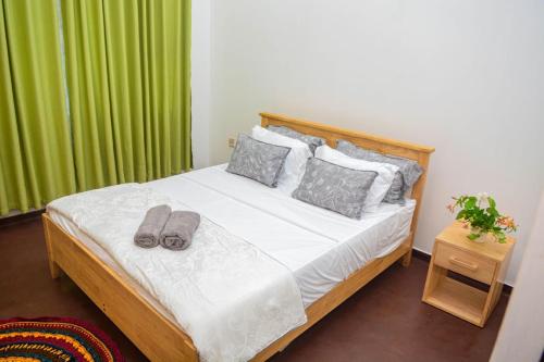 a bedroom with a bed with two slippers on it at Villa for leisure and work at Kalutara suburbs in Bandaragama