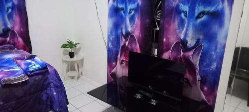 a room with a tv and a room with a wolf at Holiday rooms in St Thomas Jamaica in Clifton