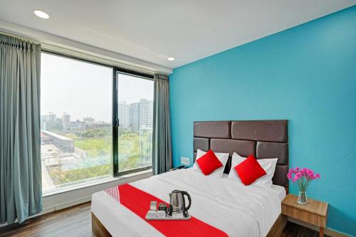 Un dormitorio con una cama grande con almohadas rojas. en Hotel O Infinity, en Surat
