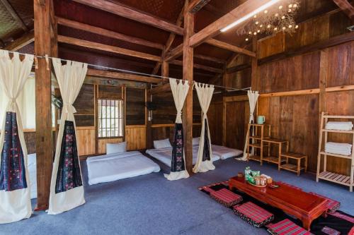 a room with two beds and a table in it at The Nordic Village - Evergreen Retreat in Mộc Châu