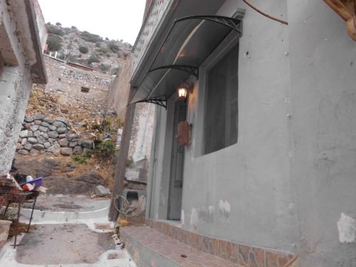a building with an awning on the side of it at Σπίτι Monemvasia Kritsas - κάτω από τη - Ροδάνθη in Kritsá